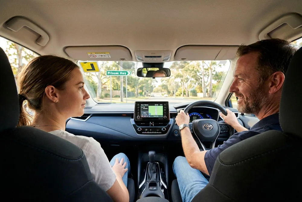 automatic driving lessons in Narre Warren – male instructor teaching beginner inside brand-new Toyota Corolla dashboard