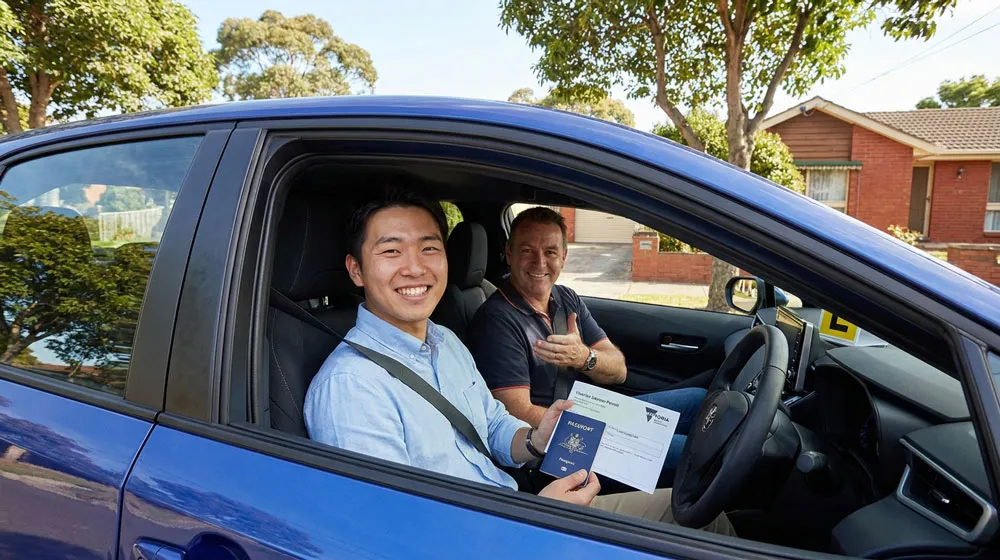 international student’s guide to getting a Victorian driver’s licence – happy student with instructor in automatic Toyota Corolla